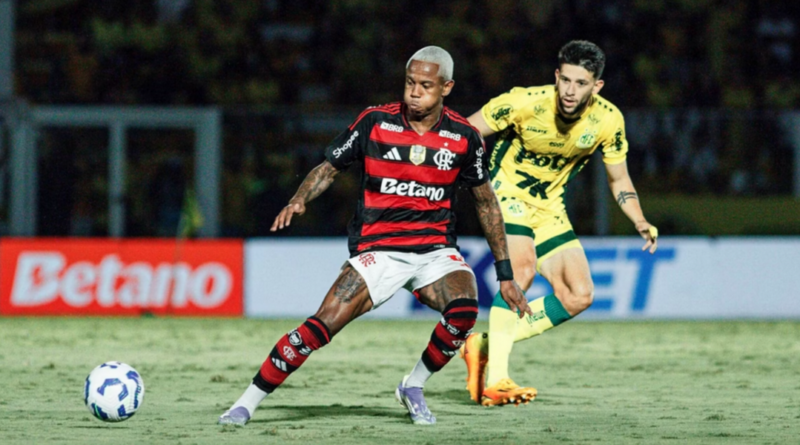 Michael, atacante do Flamengo, conduz a bola durante partida contra o Mirassol; um defensor da equipe paulista o persegue de perto no gramado do Estádio Maião.